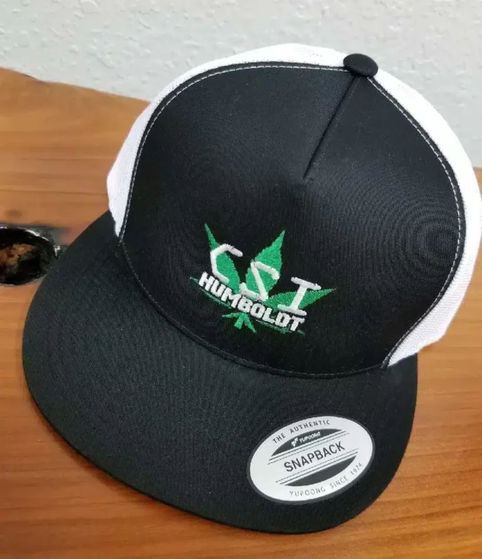 a black and white hat with white and green text